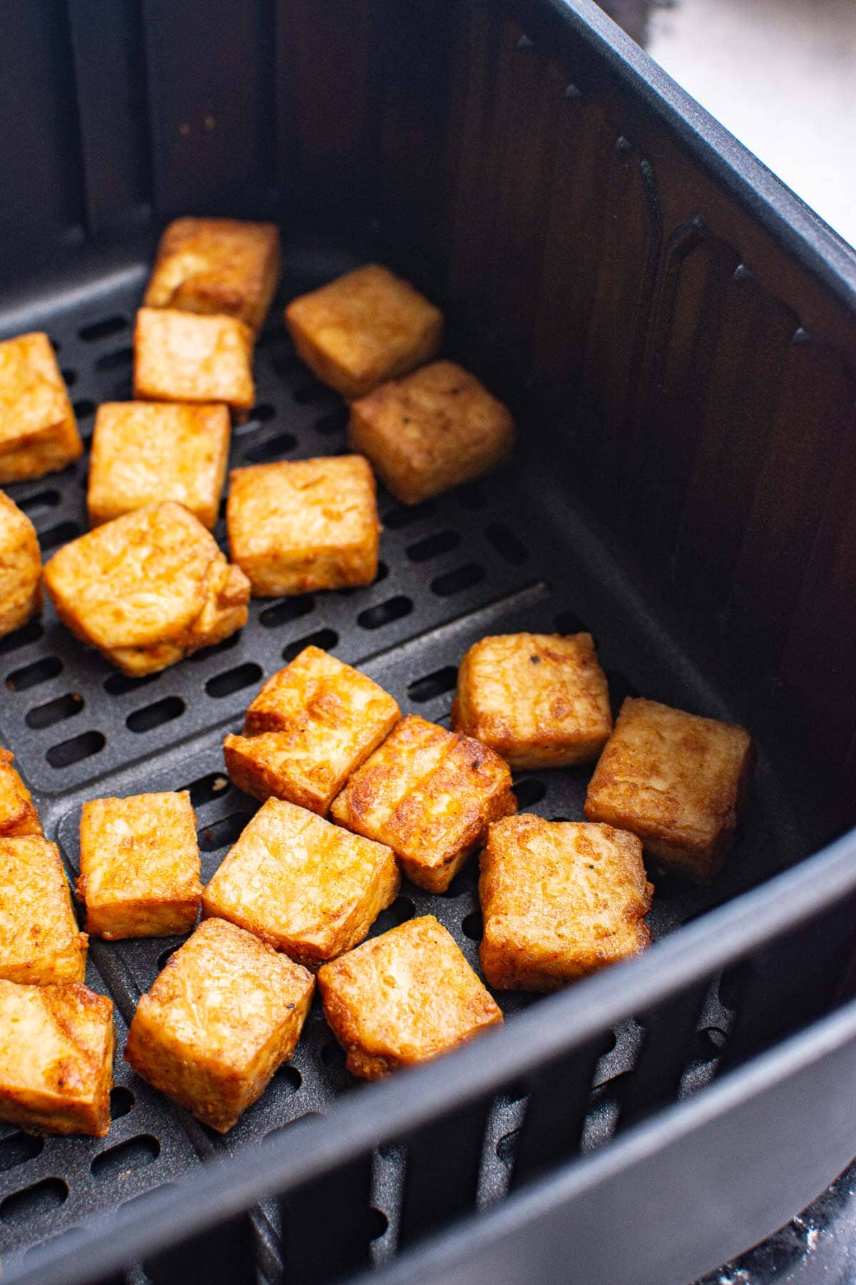 Closeup of air fryer tofu in the basket.