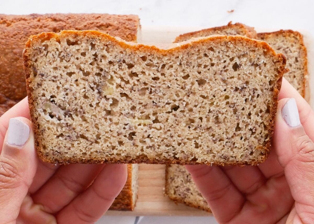 Holding a slice of almond flour banana bread in hands.