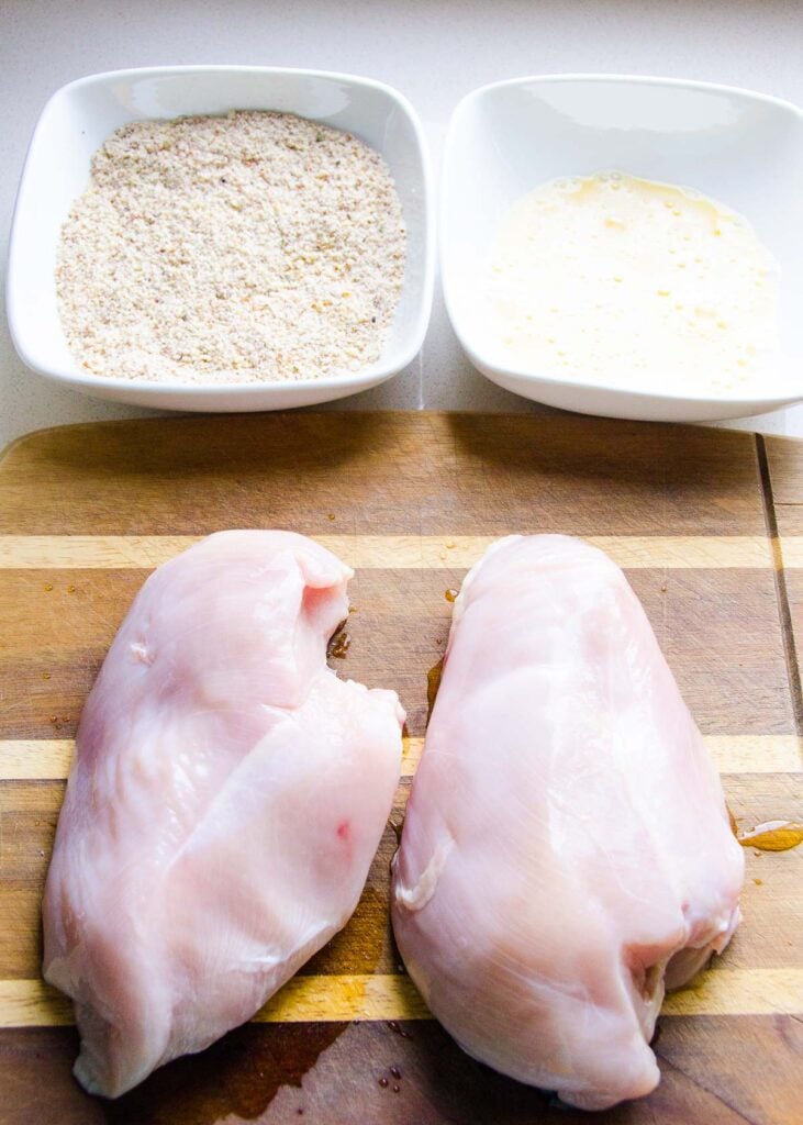 Chicken breast and almond flour ingredients in bowls.