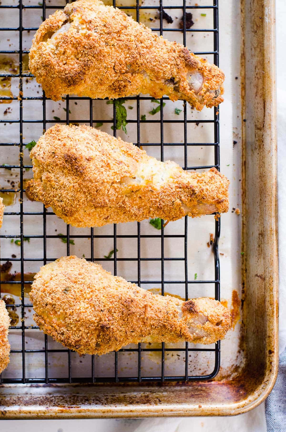 Close up of three oven baked fried chicken drumsticks.