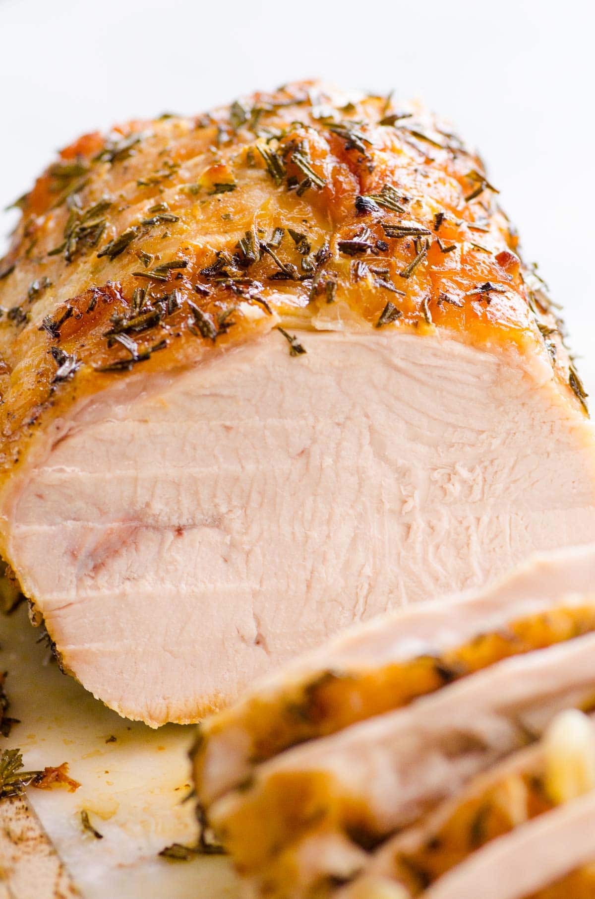 Sliced boneless turkey breast roast on cutting board.