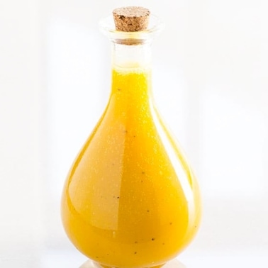 Healthy honey mustard dressing in glass jar.