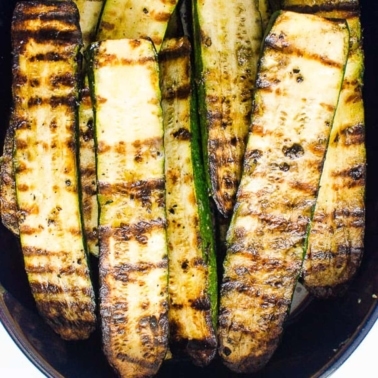 Grilled zucchini slices in a baking dish.