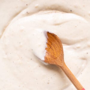 Healthy alfredo sauce on a wooden spoon.