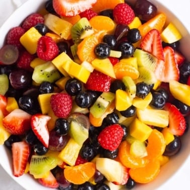 Healthy fruit salad with a honey lemon dressing in a bowl.