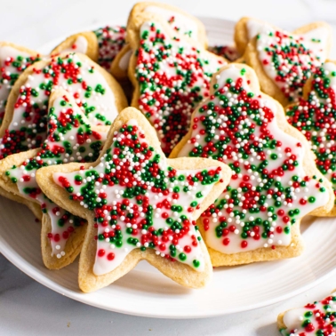 Decorated healthy sugar cookies with icing and sprinkles on a plate.