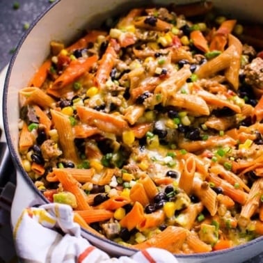 Healthy taco pasta in one pot with a towel around the handle.