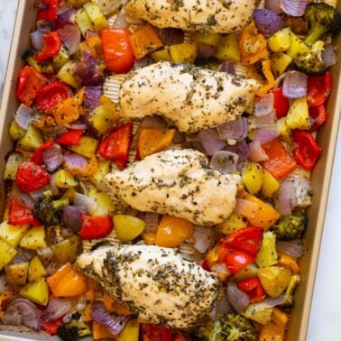 Sheet pan chicken and veggies roasted on a baking pan.