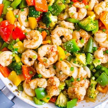 shrimp broccoli and bell pepper in a large skillet with stir fry sauce