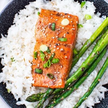 Baked teriyaki salmon with rice and asparagus for serving.