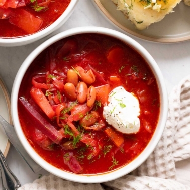 Vegetarian borscht served in a bowl with sour cream and dill.