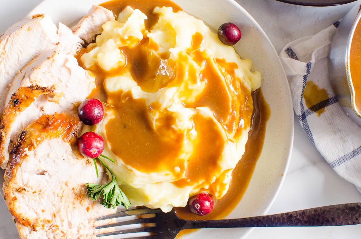 Healthy gravy served with mashed potatoes and turkey on a plate.