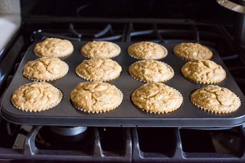 Baked banana applesauce muffins in a muffin tin on stovetop.