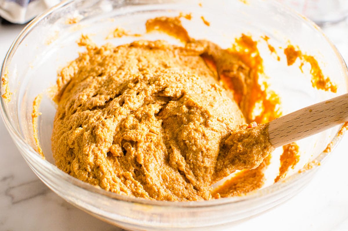 Pumpkin muffin batter in a bowl with spatula.
