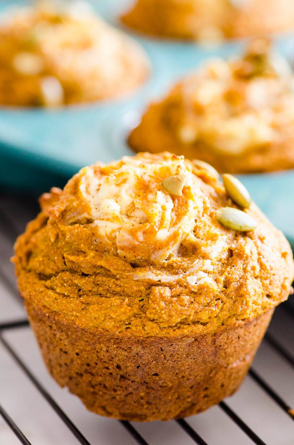 Close up of healthy pumpkin cream cheese muffin on baking rack.