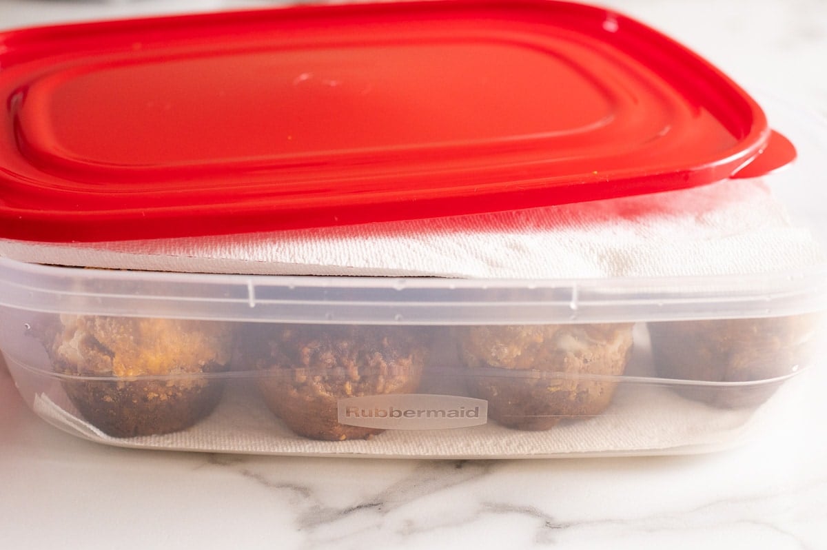 Muffins in a container lined with paper towels.
