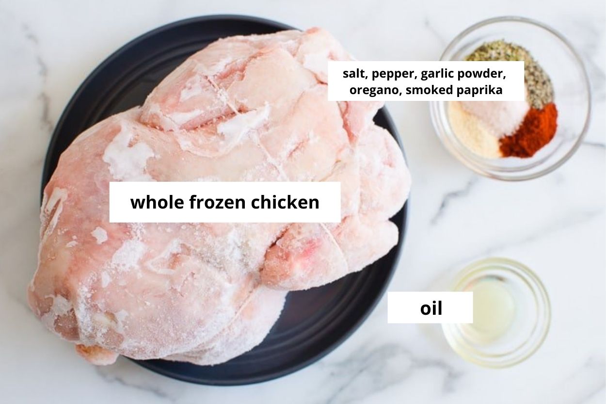 Whole frozen chicken on a plate, try the regular call my garlic powder, smoked paprika, salt and pepper and oil in bowls.
