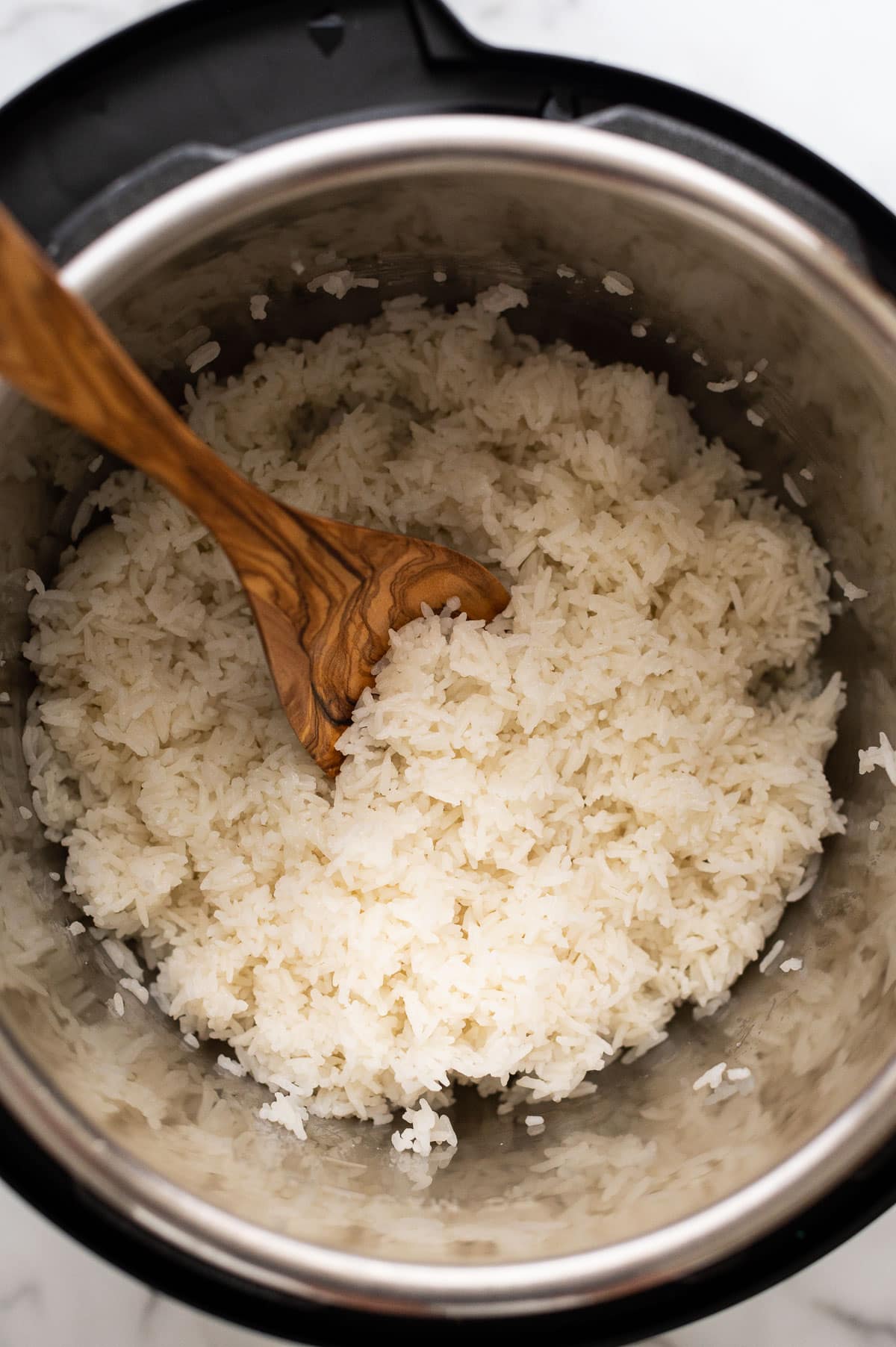 Instant pot Jasmine rice with wooden spoon in the pot.
