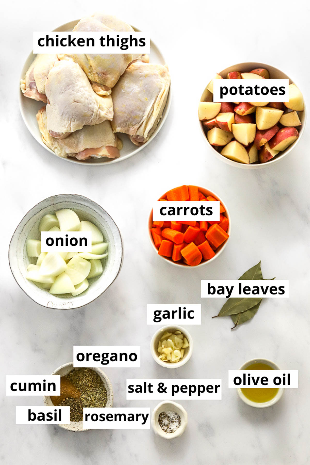Chicken thighs, potatoes, carrots, onion, bay leaves, garlic, oregano, basil, cumin, rosemary, oil, salt and pepper.