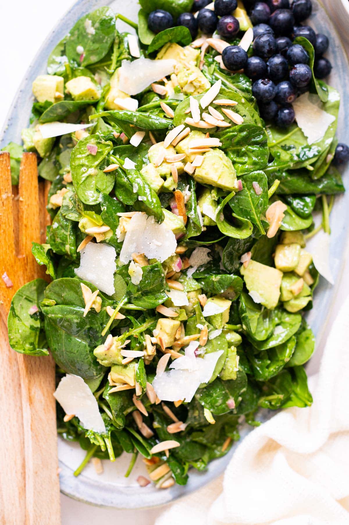 Spinach avocado salad with almonds, parmesan cheese and blueberries.