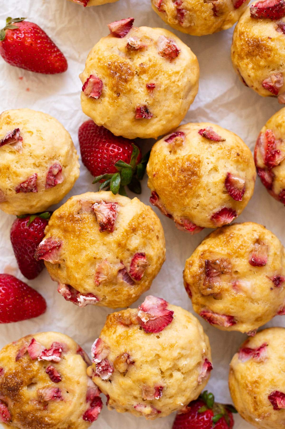 View from the top on strawberry muffins dotted with pieces of strawberries.