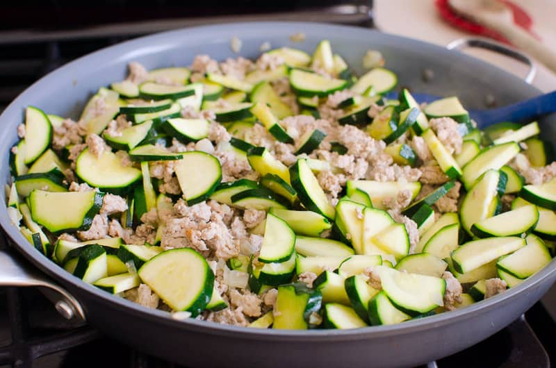 Ground turkey and chopped zucchini in skillet.