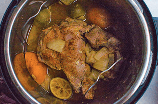 cooked pork shoulder with aromatics in instant pot